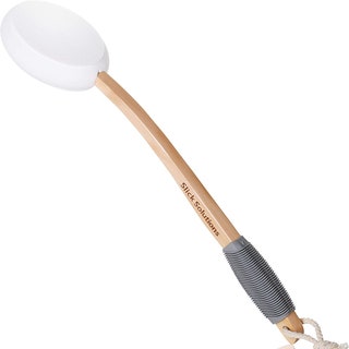 wooden lotion applicator with a white silicone head on a white background